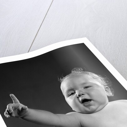 1940s 1950s baby sitting in chair arm and one finger raised objecting voting making a point looking at camera by Anonymous
