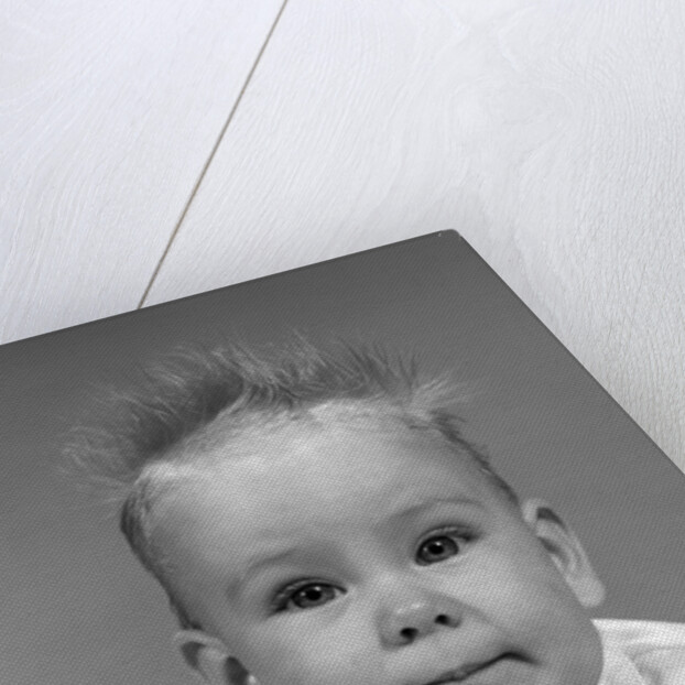 1960s head on portrait of baby girl in ruffled dress straight up hair looking at camera by Anonymous