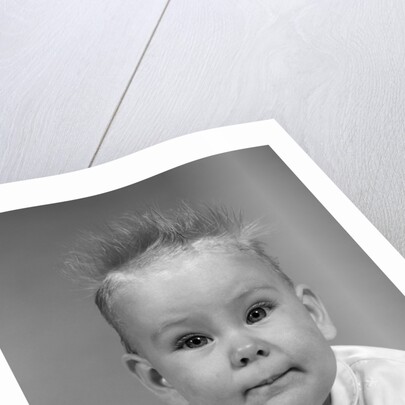 1960s head on portrait of baby girl in ruffled dress straight up hair looking at camera by Anonymous