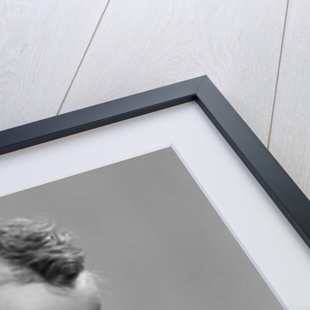 1950s baby sitting leaning forward drinking from bottle studio indoor by Anonymous