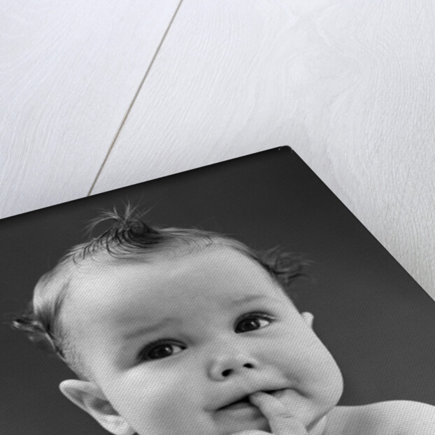1940s thoughtful baby with finger in mouth by Anonymous