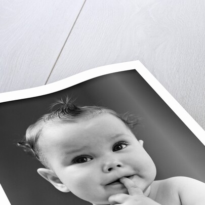 1940s thoughtful baby with finger in mouth by Anonymous