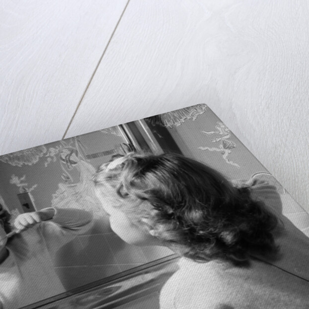 1950s girl looking in bathroom mirror brushing teeth by Anonymous