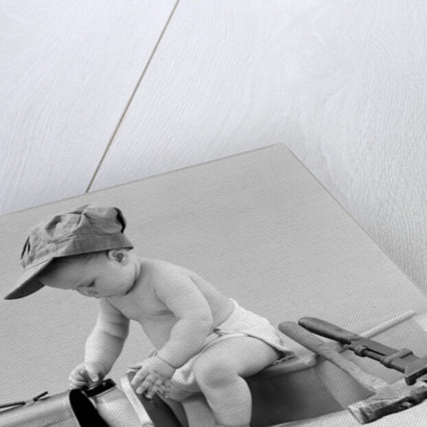 1940s baby in railroad engineer hat pulling milk bottle from lunch pail with hammer & wrench tools at side studio by Anonymous