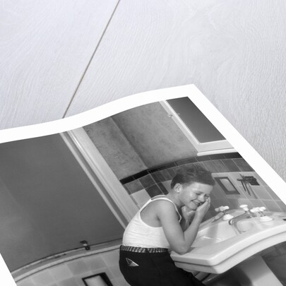 1930s boy washing face at bathroom sink by Anonymous
