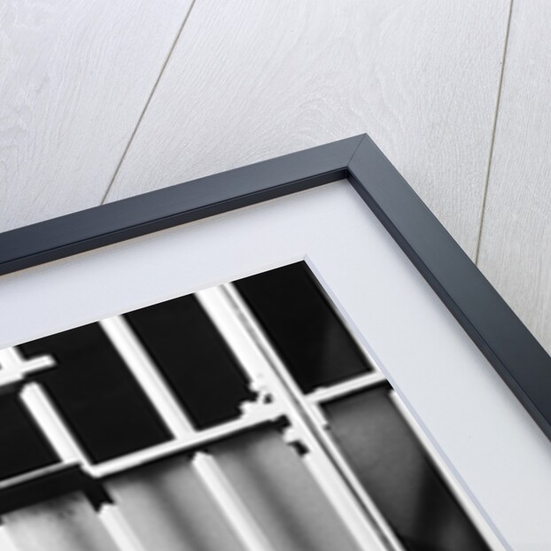 1960s man seated on bench in jail cell with head in hand looking downward by Anonymous