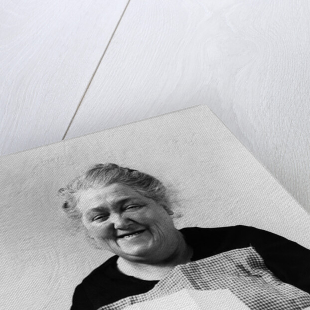 1930s 1940s elderly character woman smiling reading letter wearing apron looking at camera by Anonymous