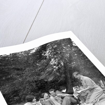1920s four people two couples men women sitting on ground enjoying a picnic by Anonymous