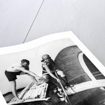 1920s man and woman in bathing suits crabbing off old abandoned wooden boat by Anonymous
