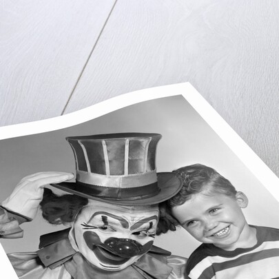 1950s smiling clown with top hat arm around grinning boy in striped shirt by Anonymous