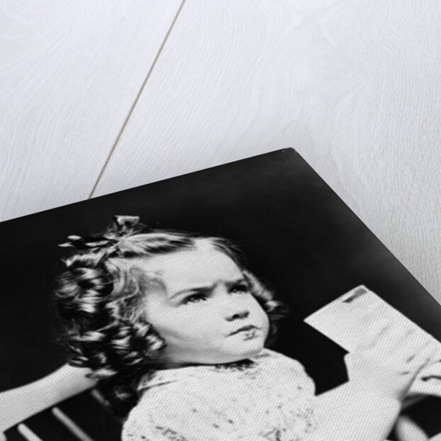 1930s child girl sitting in high chair holding glass of milk serious look bow in hair baloney curls by Anonymous