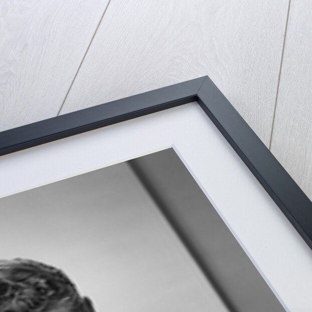 1950s smiling man in suit and tie sitting at table holding knife and fork eating dinner by Anonymous