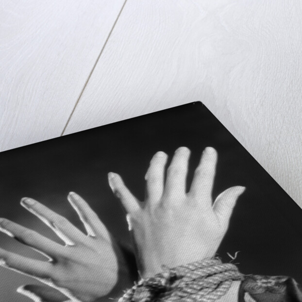 1930s woman's hands tied together by rope overhead view by Anonymous