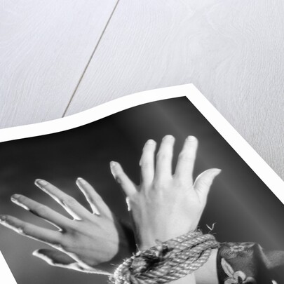 1930s woman's hands tied together by rope overhead view by Anonymous