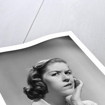 1950s 1960s woman portrait worried facial expression hand to cheek tooth pain by Anonymous