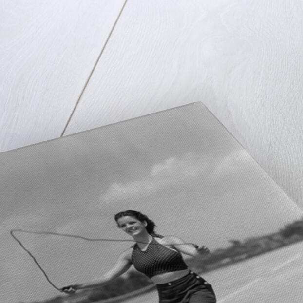 1930s woman jumping rope exercise outdoors wearing polka dot halter top and shorts by Anonymous