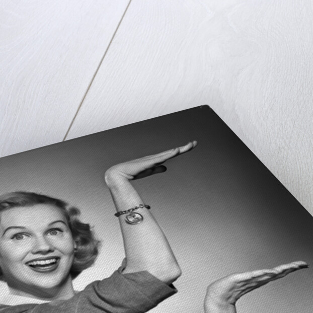 1950s 1960s happy smiling blond woman gesturing with hands showing size of something looking at camera by Anonymous