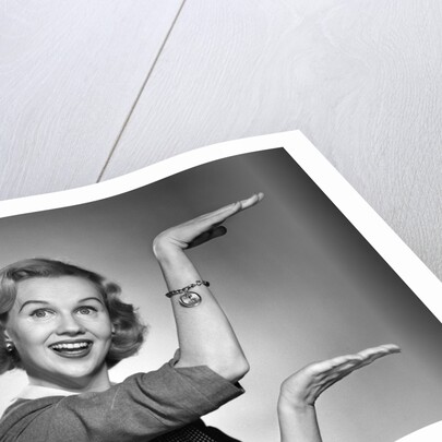1950s 1960s happy smiling blond woman gesturing with hands showing size of something looking at camera by Anonymous