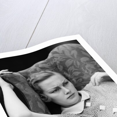 1930s woman sitting slumped position with a worried expression and a furrowed brow by Anonymous