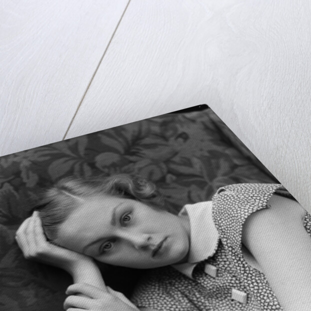 1930s woman moping looking sad or depressed or with a headache leaning her head on her hand looking at camera by Anonymous