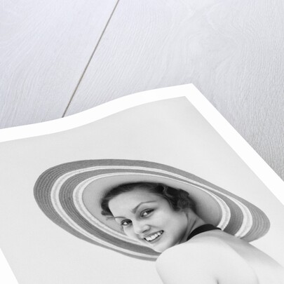 1930s woman wearing striped halter top and very wide brim straw hat looking at camera over shoulder by Anonymous