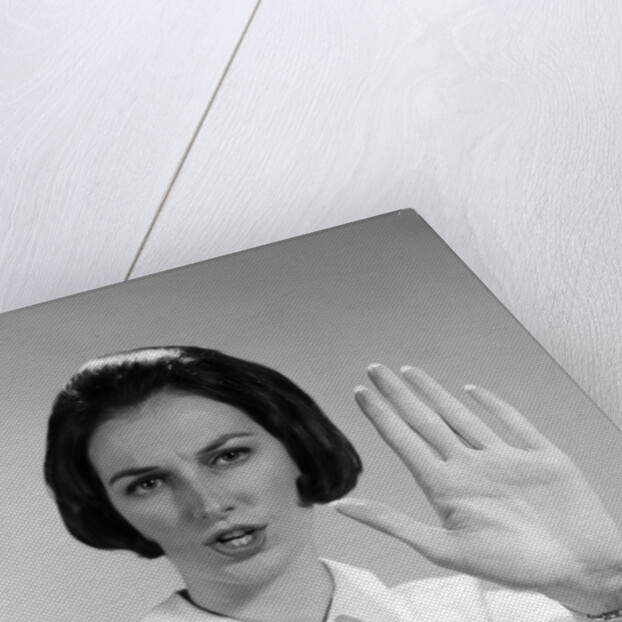 1960s woman looking at camera holding up hand palm forward commanding stop by Anonymous