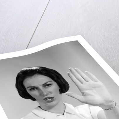 1960s woman looking at camera holding up hand palm forward commanding stop by Anonymous