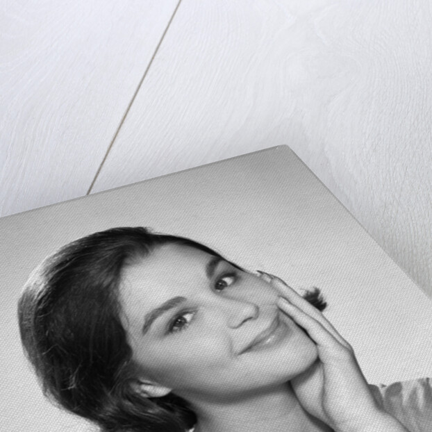 1960s smiling brunette young woman hand to cheek facial expression gesture looking at camera by Anonymous