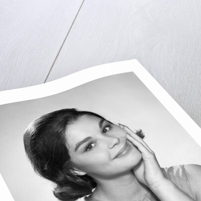 1960s smiling brunette young woman hand to cheek facial expression gesture looking at camera by Anonymous