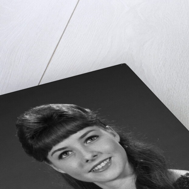 1960s portrait of smiling young woman in sequin dress looking at camera by Anonymous