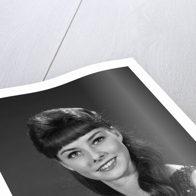 1960s portrait of smiling young woman in sequin dress looking at camera by Anonymous