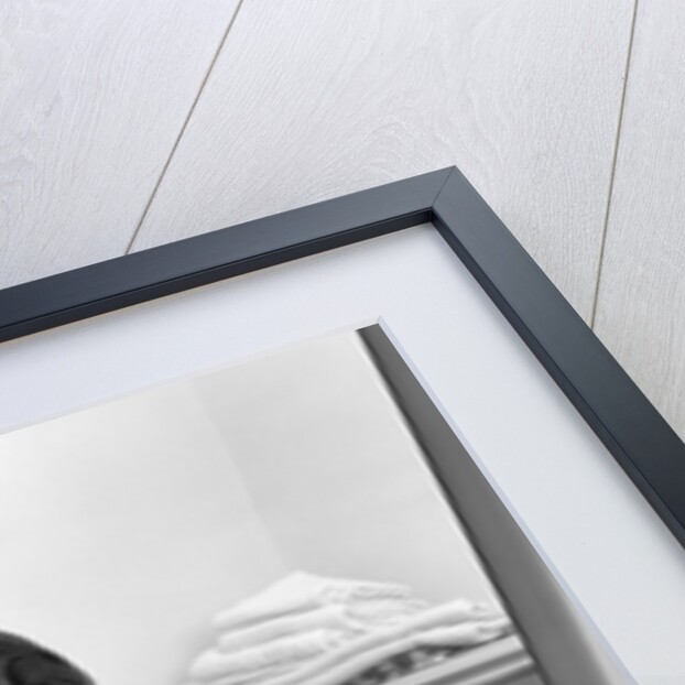 1960s woman holding laundry folded towels by linen closet looking at camera by Anonymous