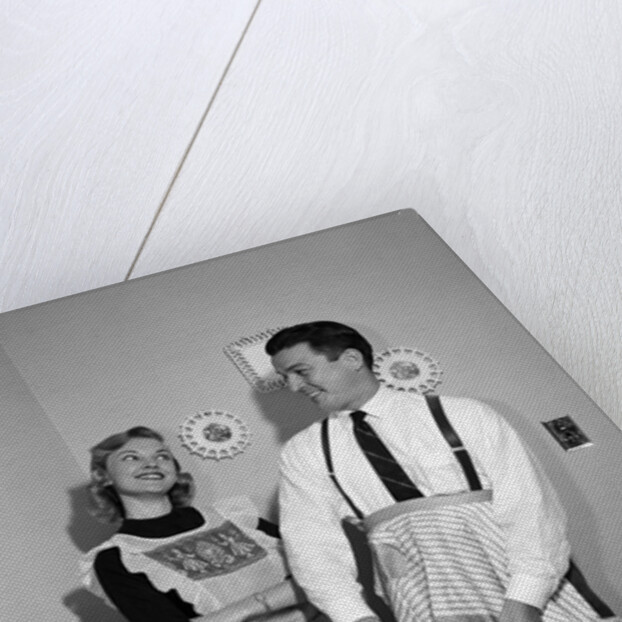 1950s satisfied amused smiling couple husband wife in kitchen cooking together by Anonymous