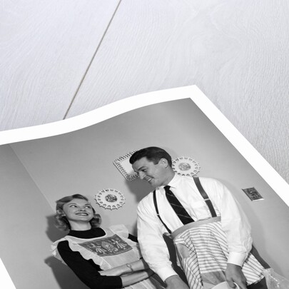 1950s satisfied amused smiling couple husband wife in kitchen cooking together by Anonymous
