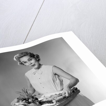 1950s woman looking at camera smiling holding platter of hors d'oeuvres snacks by Anonymous