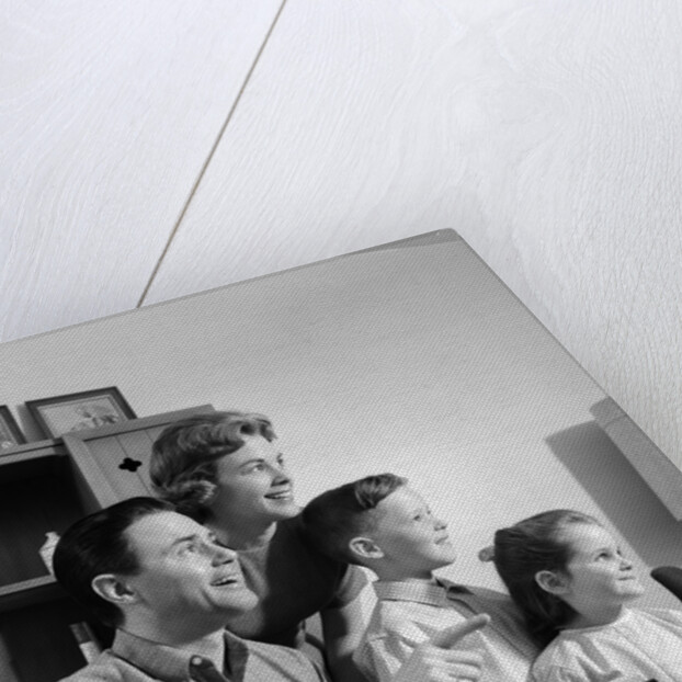 1960s happy family looking at slides on slide projector by Anonymous