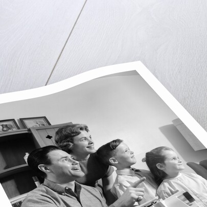 1960s happy family looking at slides on slide projector by Anonymous