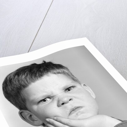 1960s little boy making angry funny facial expression looking at camera by Anonymous