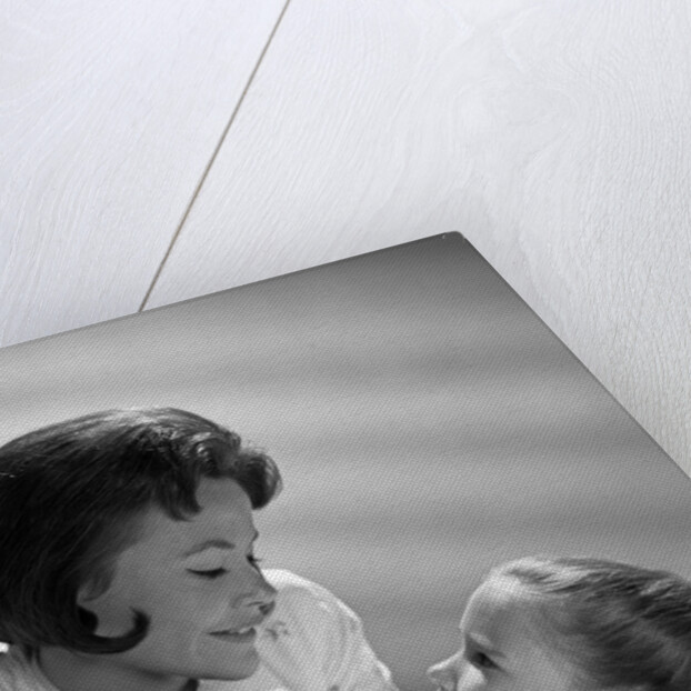 1960s daughter with mother tucking into bed by Anonymous