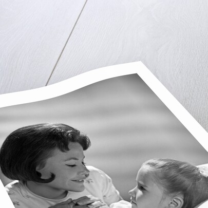 1960s daughter with mother tucking into bed by Anonymous
