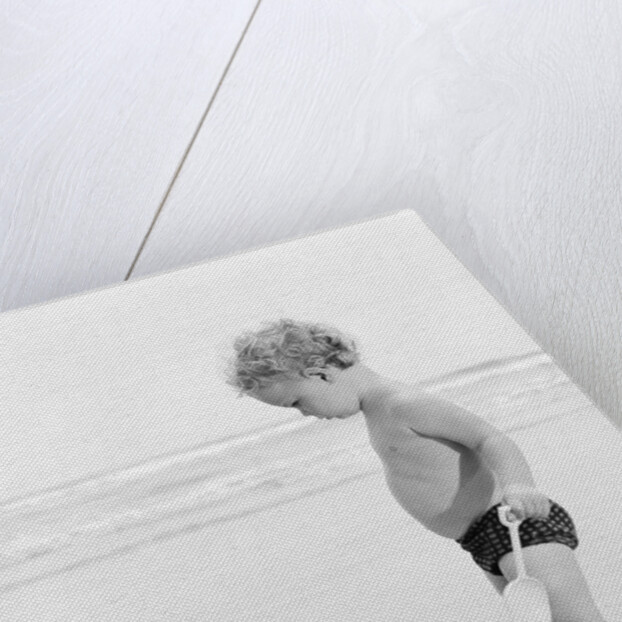 1960s 1970s child toddler standing in sand water bucket shovel by Anonymous