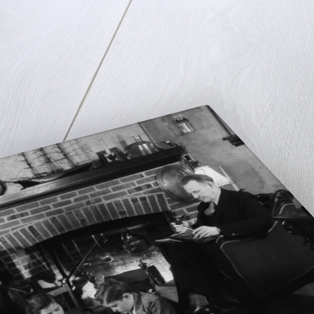 1930s family of four sitting in front fireplace mother knitting father reading smoking pipe kids doing homework by Anonymous