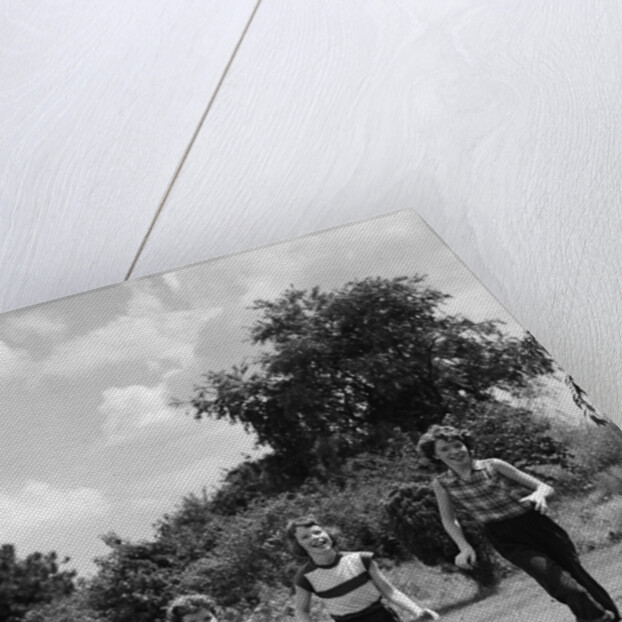 1950s three girls running in grassy field by Anonymous