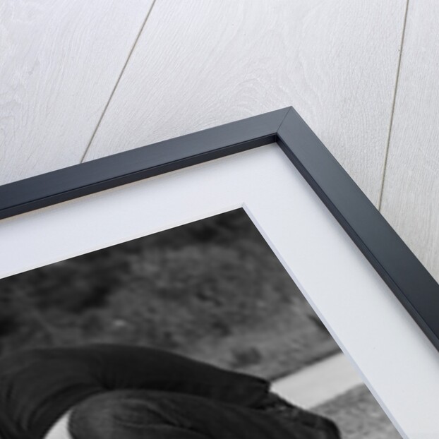 1950s teen boy helping girl put on metal roller skates sitting on sidewalk by Anonymous