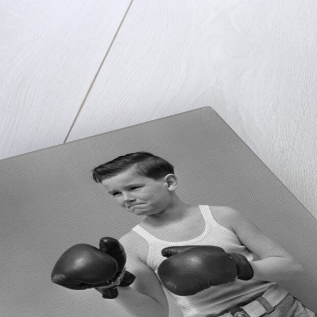 1940s boy child wearing boxing gloves standing ready to fight by Anonymous