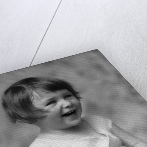 1930s smiling laughing toddler girl holding shoe by Anonymous