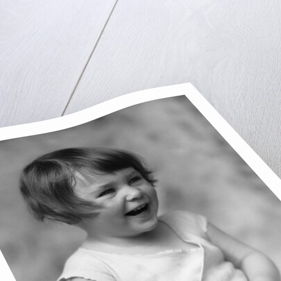 1930s smiling laughing toddler girl holding shoe by Anonymous