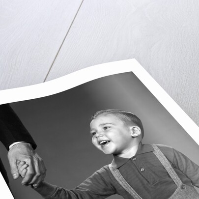 1960s boy holding adult male hand smiling by Anonymous
