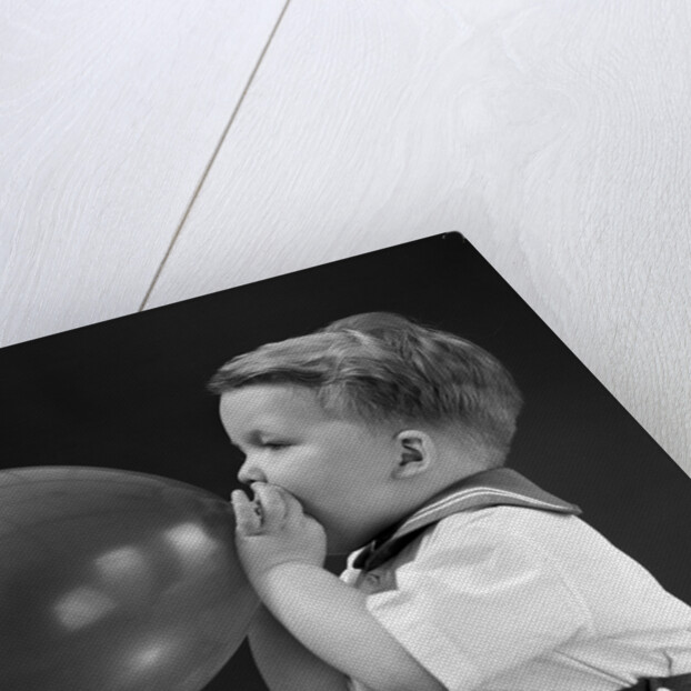 1940s boy blowing up balloon by Anonymous