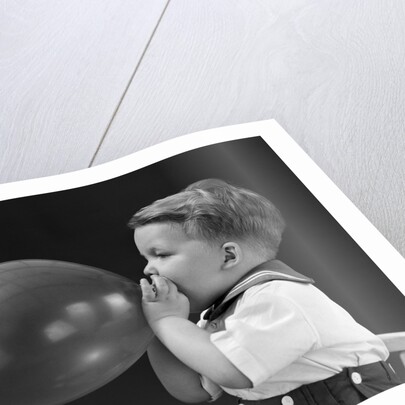 1940s boy blowing up balloon by Anonymous